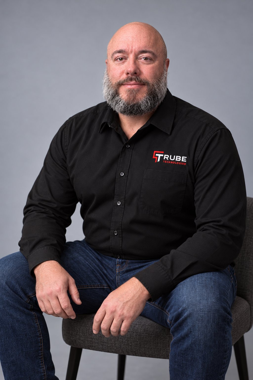 Brandon M. Trube, owner of Trube Technologies, seated in a studio portrait